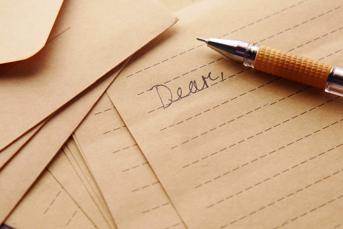 A pen resting on paper — correspondence on a desk